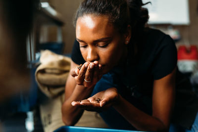 Young woman smelling roasted coffee beans