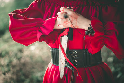 Midsection of woman with red umbrella