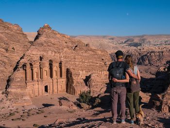 Rear view of couple standing against historical building at desert