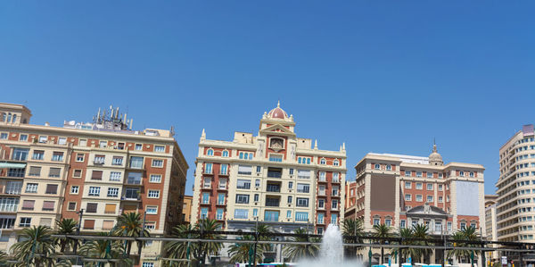 Low angle view of buildings against clear blue sky