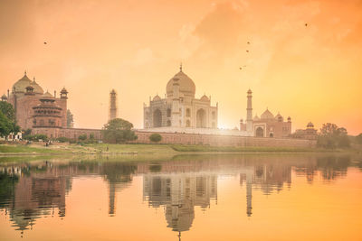 Reflection of buildings in lake at sunset