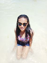 Portrait of smiling young woman in water at beach