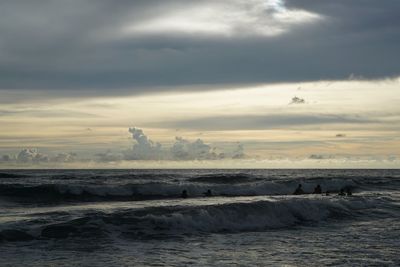 Scenic view of sea against cloudy sky during sunset