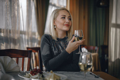 Young woman drinking glass on table