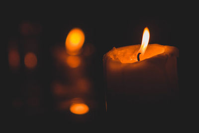 Close-up of illuminated candle in darkroom