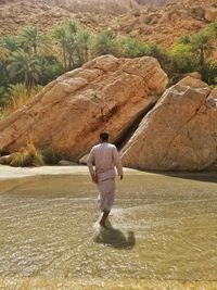 Rear view of man standing on rock