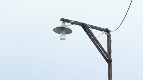 Low angle view of telephone pole against clear sky