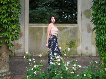 Portrait of smiling woman standing against plants