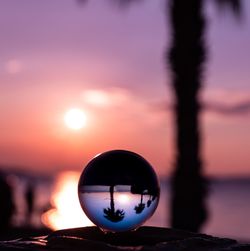 Close-up of silhouette crystal ball against sky during sunset