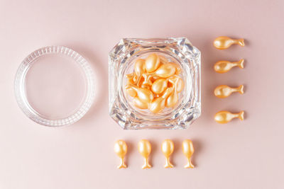 Face care oil capsules on pink background. single use nourishing oil for dry and damaged skin. 