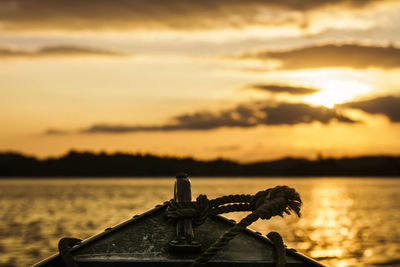 Close-up of boat against sky during sunset