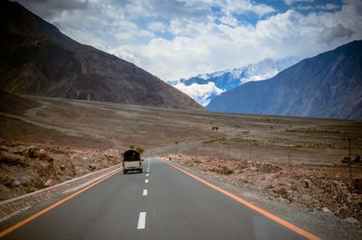 Scenic view of mountain road against cloudy sky