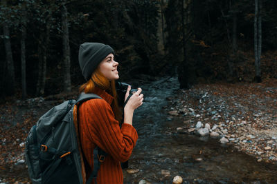 Side view of young woman in forest