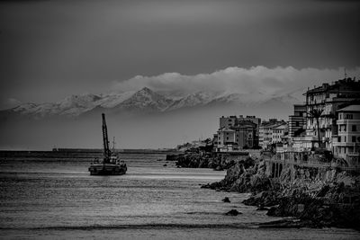 Scenic view of sea by buildings against sky