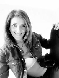 Portrait of smiling young woman against white background