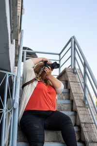 Body positive. portrait of overweight woman taking pictures with a camera outdoors