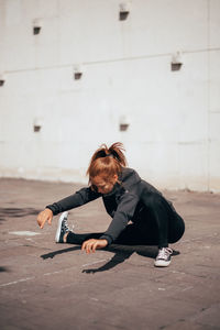 Full length of woman stretching outdoors