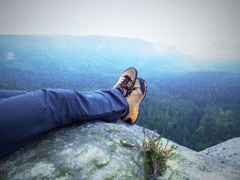 Low section of man relaxing on mountain