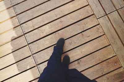 Low section of person relaxing on wooden floor