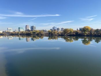 Reflection of buildings in lake against sky