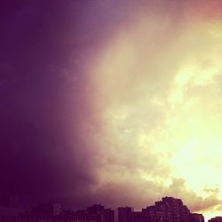 View of cityscape against cloudy sky