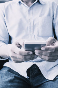 Midsection of man holding coffee cup