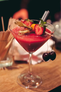 Close-up of fruit drink in martini glass on table