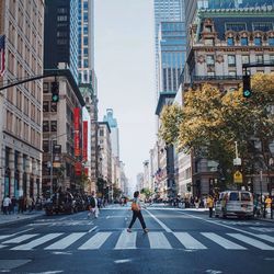 Road amidst buildings in city against sky