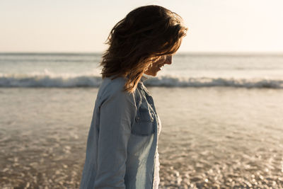 Woman standing on beach against sea