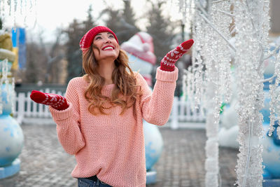 Beautiful woman wearing knit hat and sweater standing outdoors