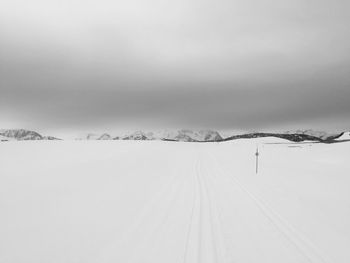 Snow covered landscape against sky