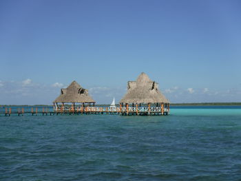 Building by sea against clear blue sky