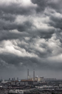 Buildings in city against cloudy sky