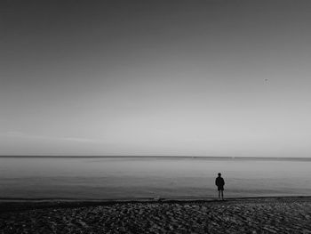 Silhouette man on beach against sky