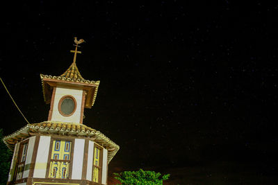 Low angle view of illuminated building against sky at night