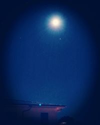 Low angle view of moon against blue sky