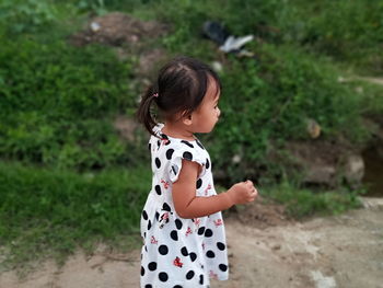 Side view of cute girl standing outdoors