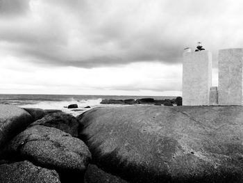 Lighthouse by sea against sky