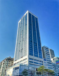 Low angle view of skyscraper against clear blue sky