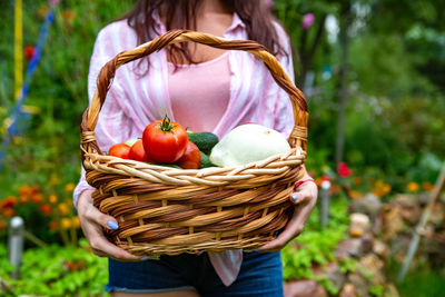 Farmer woman hold big wooden basket with fresh organic seasonal vegetables