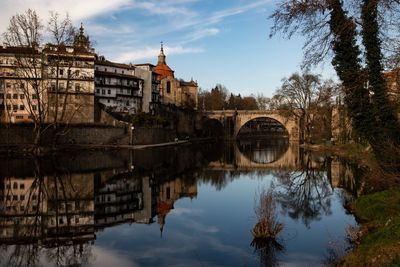 Arch bridge over river against buildings