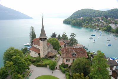 High angle view of church amidst trees by lake