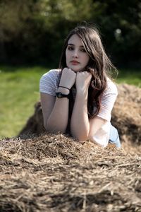 Portrait of a beautiful young woman lying on land