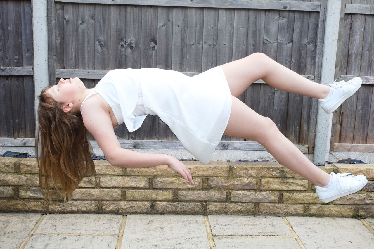 one person, women, young adult, adult, sitting, limb, human leg, lifestyles, full length, clothing, white, hairstyle, photo shoot, architecture, long hair, side view, day, leisure activity, fashion, female, person, relaxation, city, blond hair, dancing, outdoors, lying down, ballet dancer, ballet, wood, physical fitness