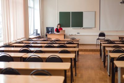 Professional woman teacher working at empty auditorium of high school or college