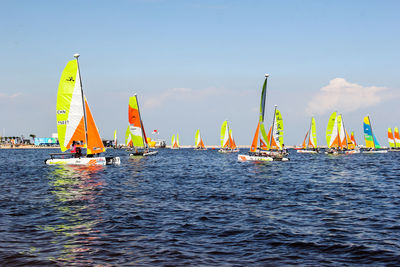 Panoramic view of people in sea against sky