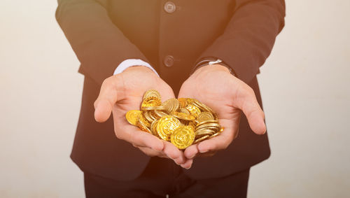 Midsection of businessman holding coins