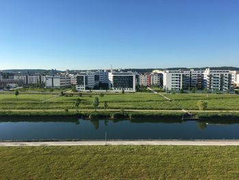 Buildings by lake against clear sky