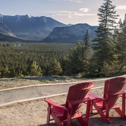 Empty chairs and tables against mountains