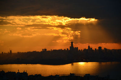 Scenic view of river against cloudy sky during sunset